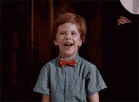 a young boy wearing a bow tie is laughing .