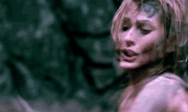 a close up of a woman 's face in a dark room with a blurred background .