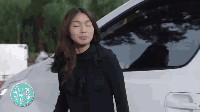 a woman is standing in front of a white van with a sign that says " still meet you "