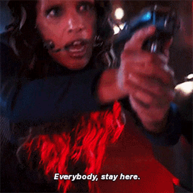 a woman holding a gun with the words everybody stay here