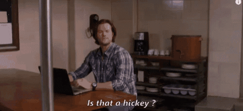 a man is sitting at a table using a laptop computer and asking is that a hickey .