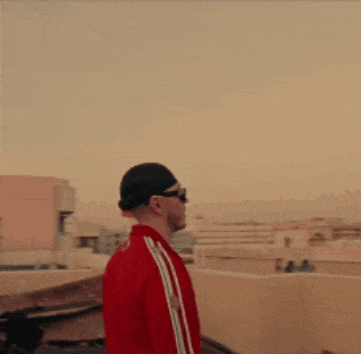 a man wearing sunglasses and a red jacket has the letter d on his jacket