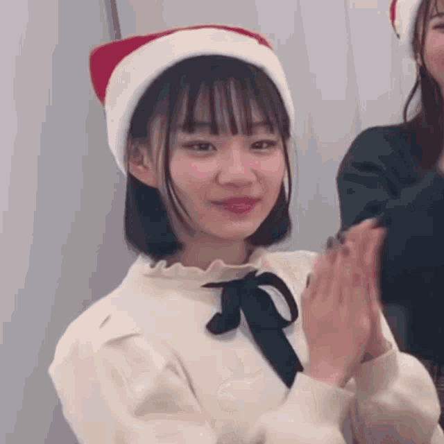 a young girl wearing a santa hat and a white sweater