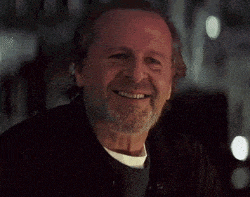 a close up of a man with a beard smiling at the camera .