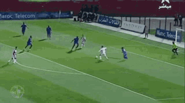 a soccer game is being played on a field with advertisements for telecom in the background .