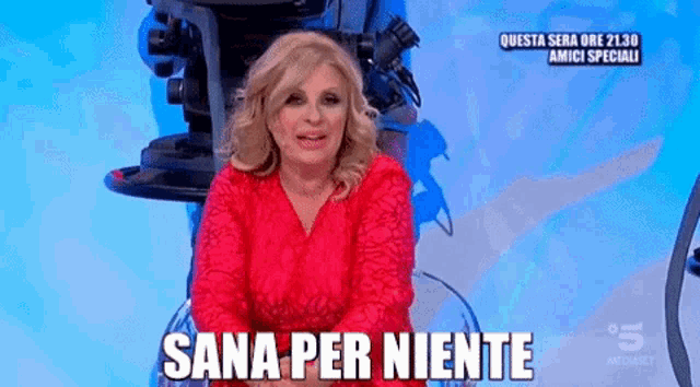 a woman in a red dress says sana per niente in front of a camera .