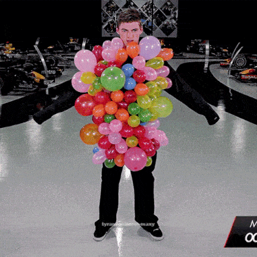 a man is surrounded by balloons and has the word tyranny on the bottom of the photo