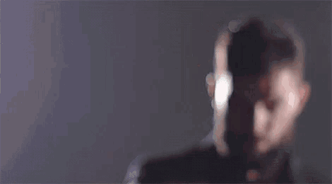 a blurry picture of a man 's face with a purple background .