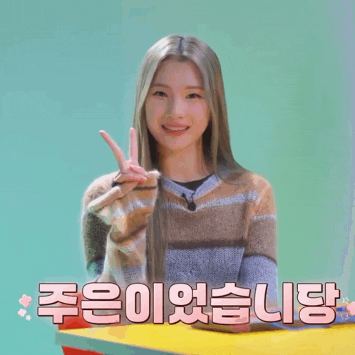 a woman giving a peace sign in front of a sign that says ' i 'm sorry '