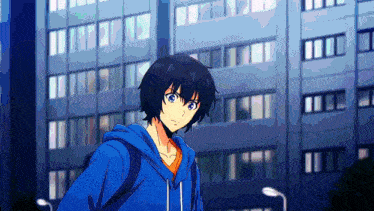 a man in a blue hoodie is standing in front of a building