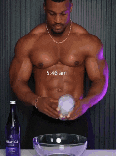 a shirtless man is standing next to a bottle of saratoga