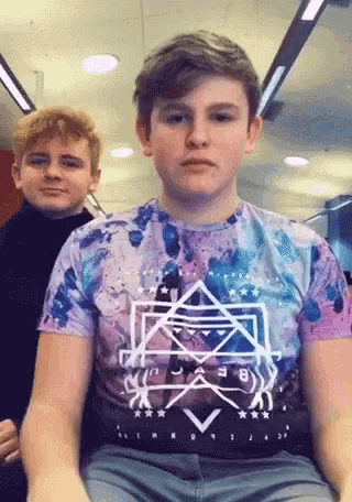 a boy wearing a purple shirt that says be brave