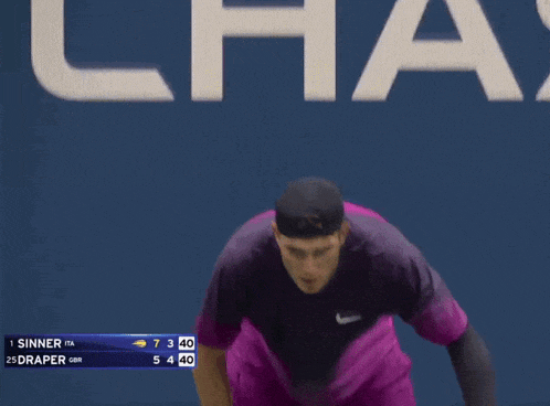 a man in purple shorts is holding a tennis racket