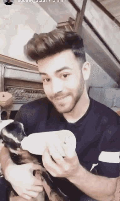 a man with a beard is holding a small puppy
