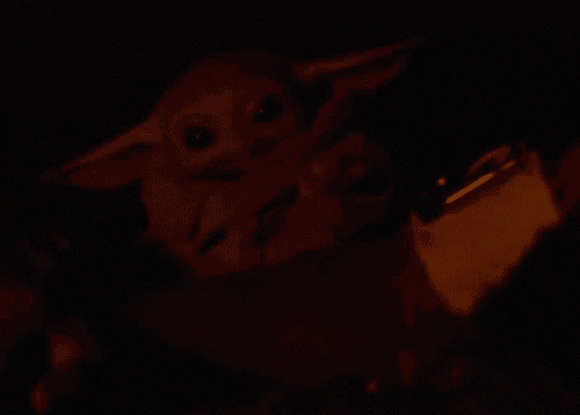 a person is holding a stuffed animal in their arms in the dark .
