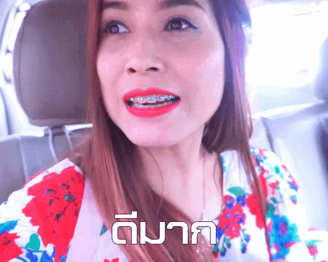 a woman with braces on her teeth is wearing a floral top