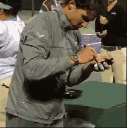 a man in a grey jacket is writing on a green box
