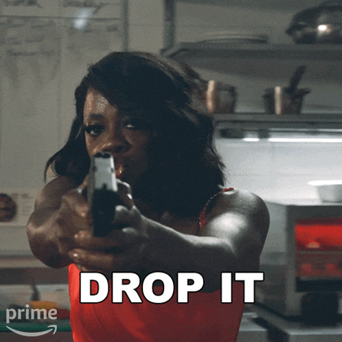 a woman is pointing a gun with the words drop it below her