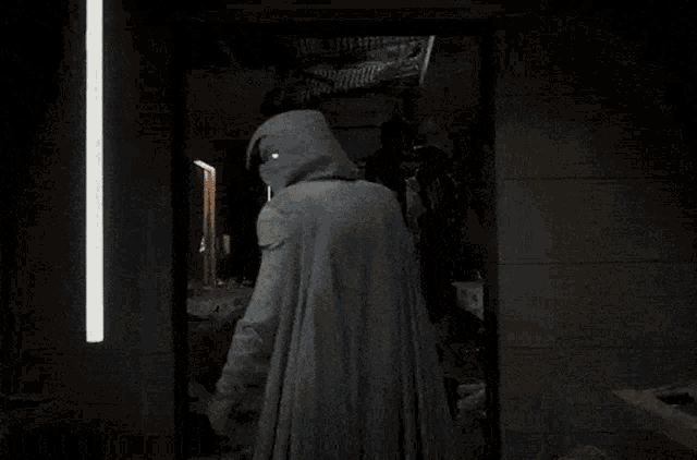 a man in a mask is standing in front of a mirror .
