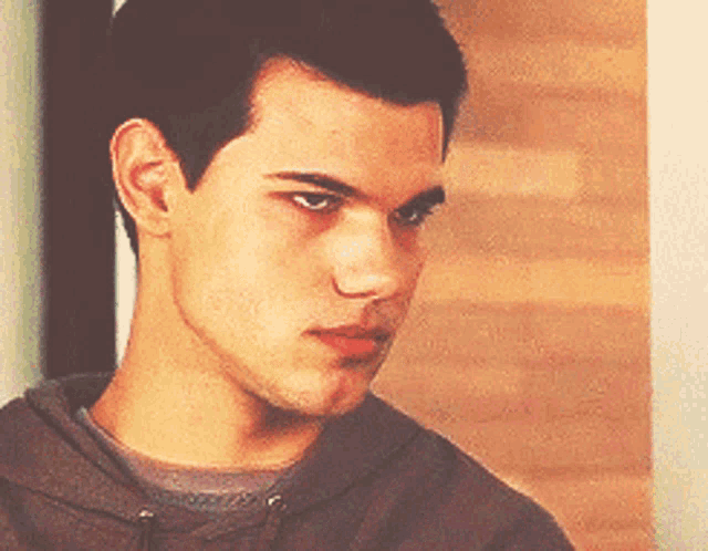 a close up of a young man 's face with a hoodie on