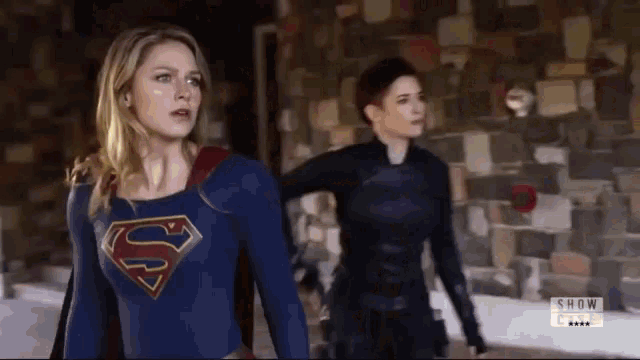 a woman in a superman costume is standing next to another woman