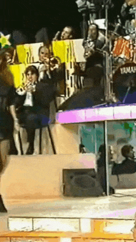 a group of people are playing instruments on a stage with a yamaha drum set in the background