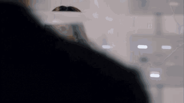 a woman looks at herself in a mirror with a circle in the background