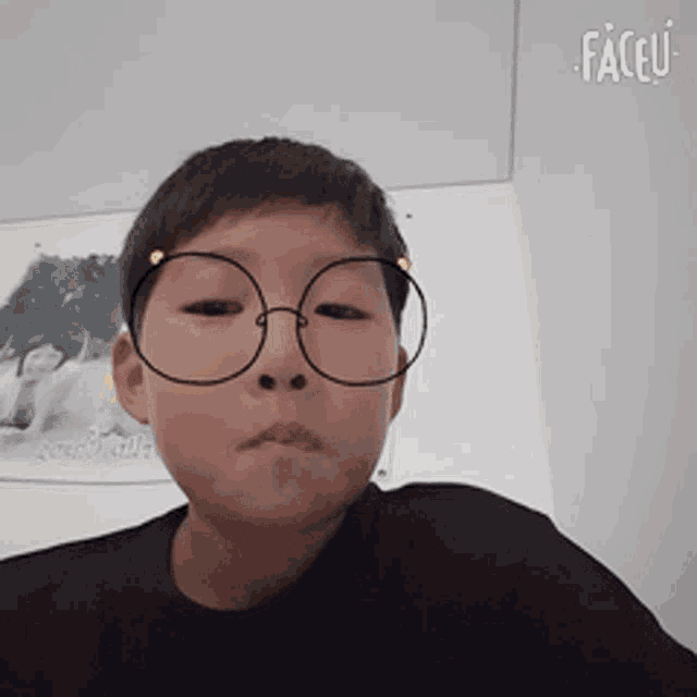 a young boy wearing round glasses with faceu written on the bottom right