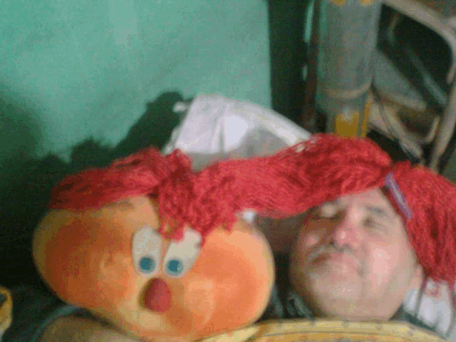 a man is laying in bed with a stuffed animal on his head
