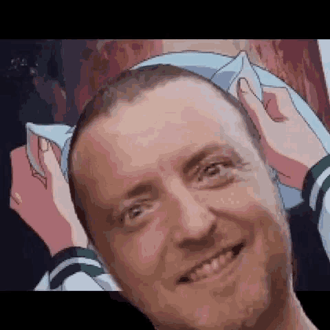 a man is smiling while holding a pillow in front of his head .