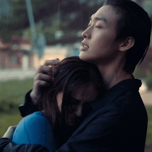 a man and a woman hugging in the rain with their eyes closed
