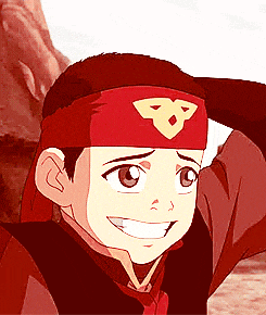 a young boy wearing a red headband with the letter b on it is smiling