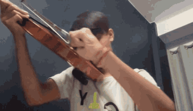 a man playing a violin with a shirt that says y on it