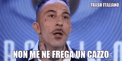 a man with blue hair is making a funny face and says non me ne frega un cazzo