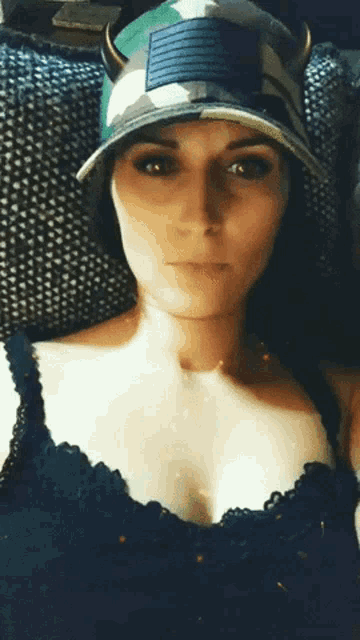 a woman wearing a hat with horns and a black bra