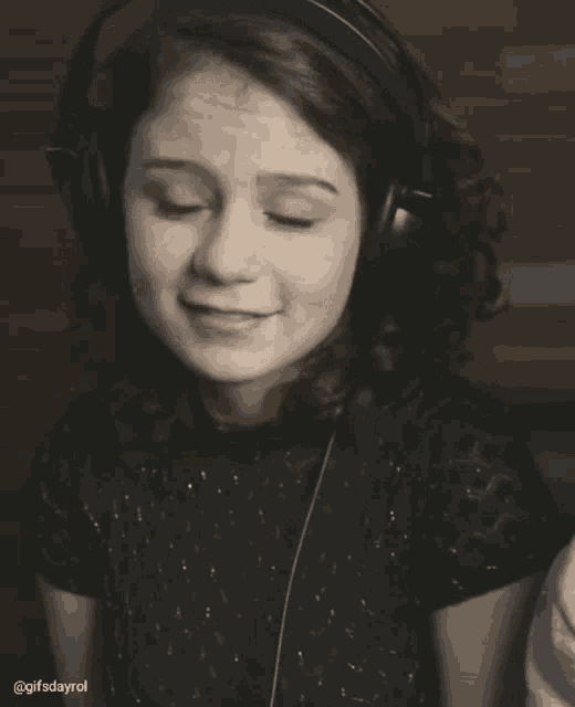 a woman wearing headphones winks at the camera