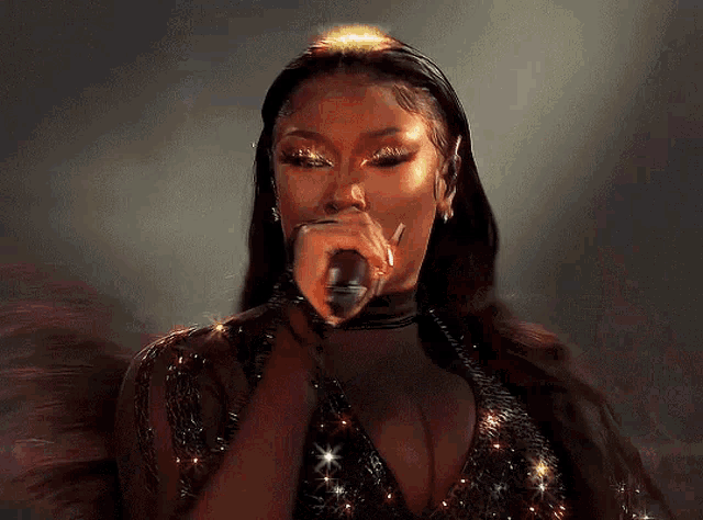 a woman is singing into a microphone on a stage .