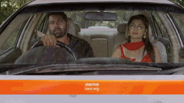 a man is driving a car with a woman sitting in the back seat ..