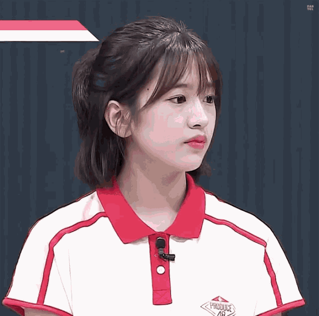 a young girl wearing a red and white polo shirt with the word produce on the front