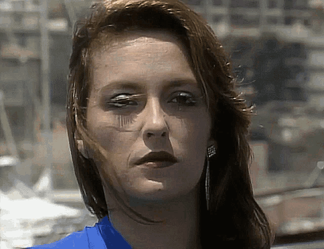 a close up of a woman 's face with a blue shirt