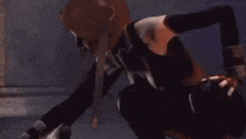 a man is kneeling down in a dark room holding a sword .