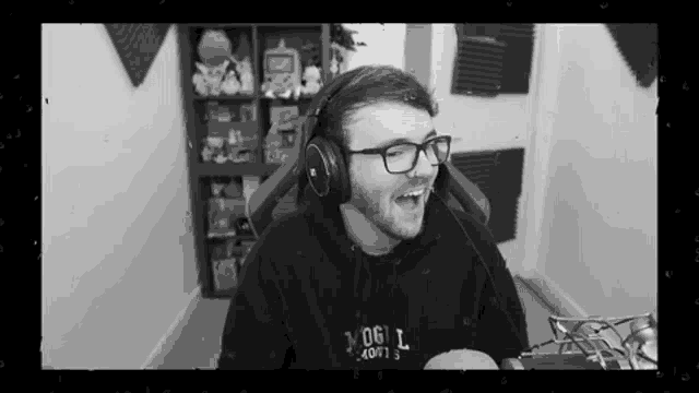 a black and white photo of a man wearing headphones and a hoodie that says vogl softs