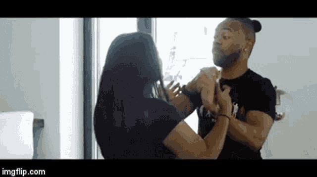 a man and a woman are dancing in front of a window with imgflip.com in the corner