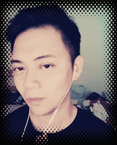 a man wearing earbuds looks at the camera