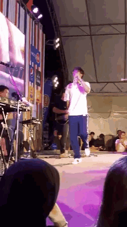 a man singing on a stage with a pepsi sign behind him