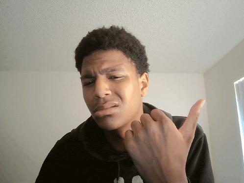 a young man making a funny face while making a call me sign