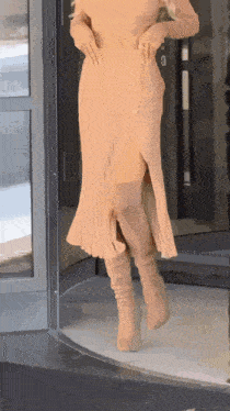 a woman wearing a pleated skirt and knee high boots