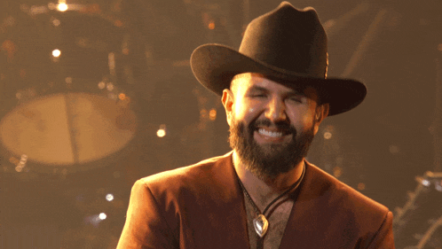 a man with a beard wearing a black cowboy hat