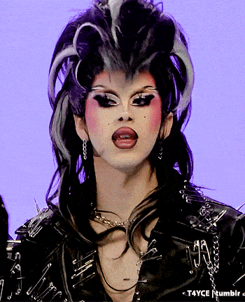 a close up of a drag queen 's face with a purple background