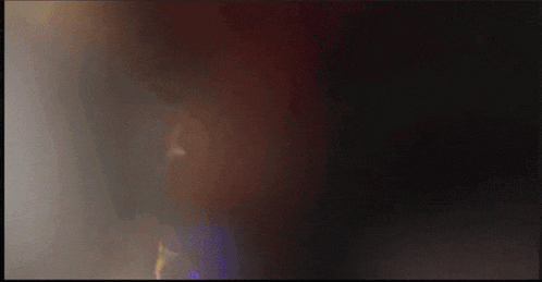 a blurred image of a person 's face with a yellow object in the background